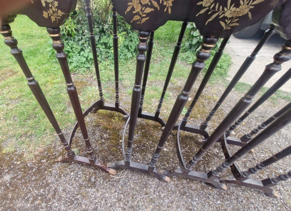 A set of four dark brown lacquered nesting tables decorated with hand-painted gilt chinoiserie landscape scenes and slender turned legs. View XIV