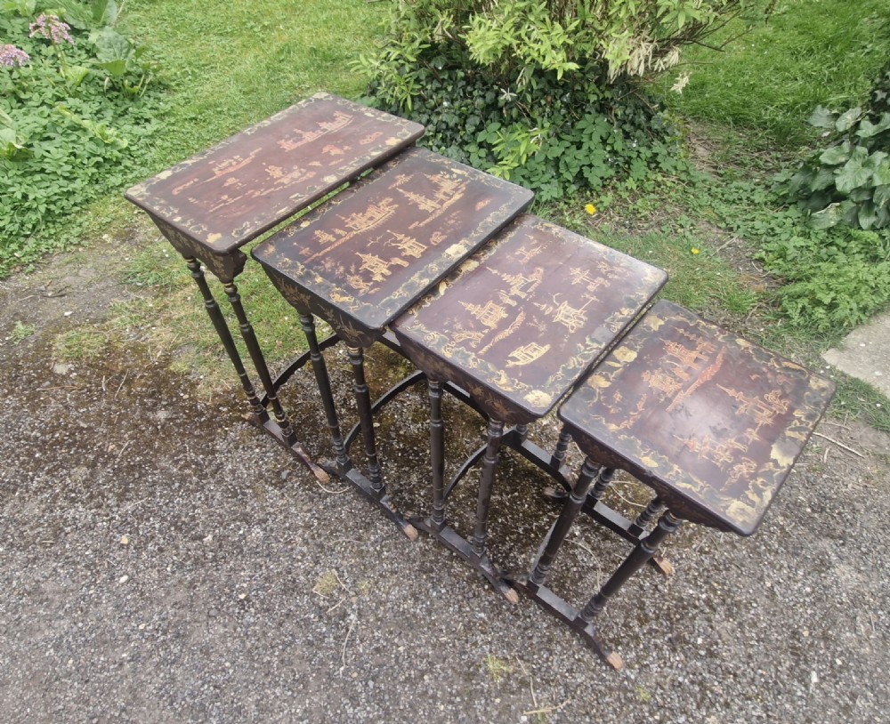 A set of four dark brown lacquered nesting tables decorated with hand-painted gilt chinoiserie landscape scenes and slender turned legs. View XV