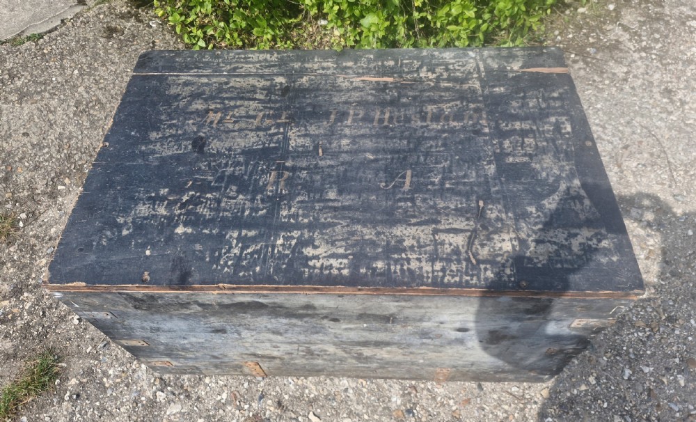 A rectangular antique dark-painted wooden campaign trunk with iron corner brackets and side carrying handles. View IV