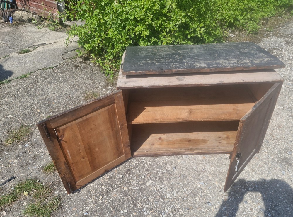 A rectangular antique dark-painted wooden campaign trunk with iron corner brackets and side carrying handles. View X