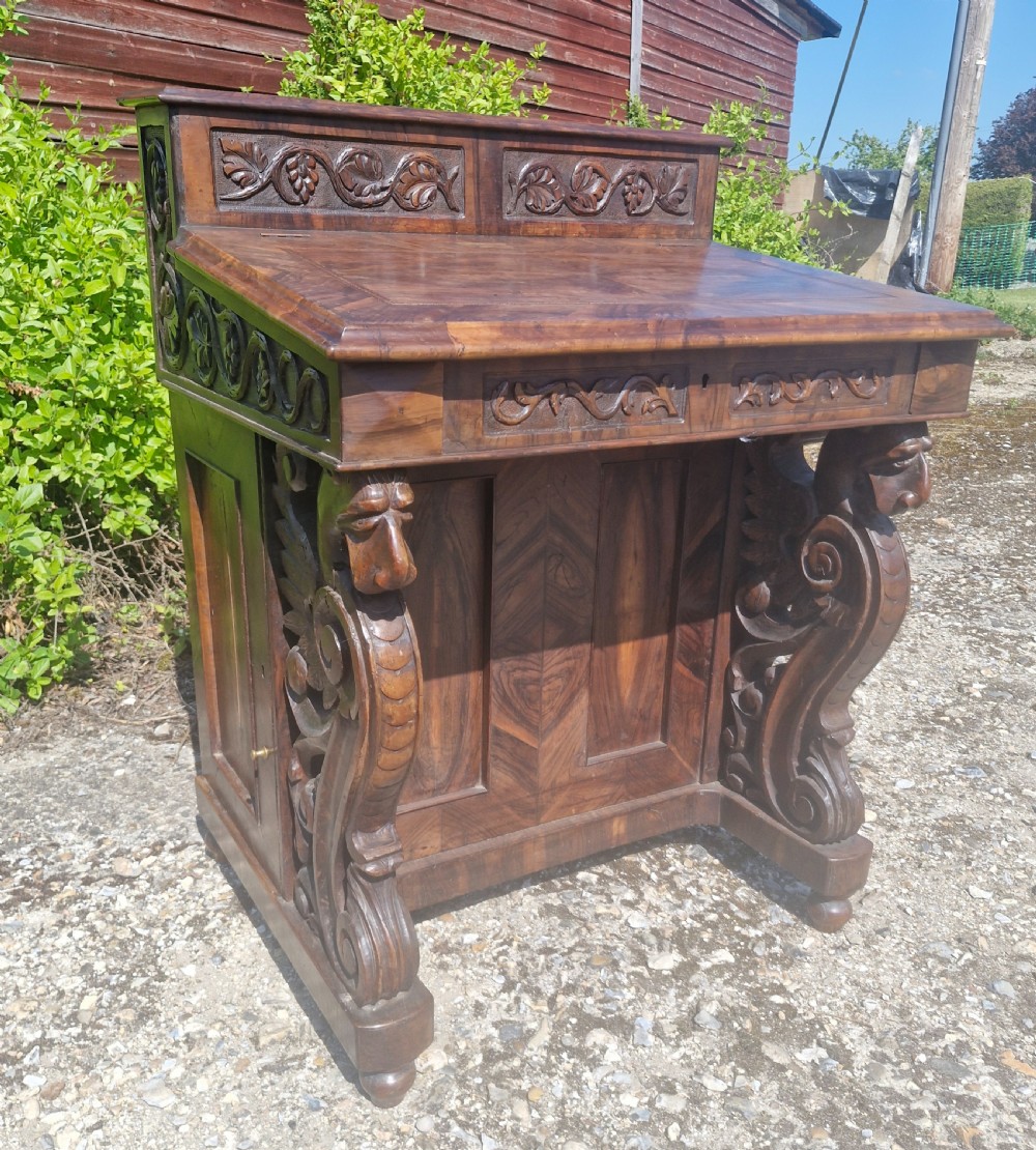 An antique carved olivewood Davenport writing desk with a sloped lid, foliage carvings, and decorative scrolled supports. View XII
