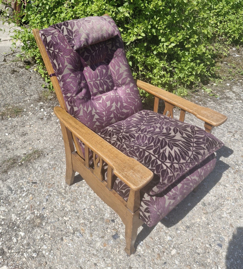 An Arts and Crafts oak reclining armchair with patterned purple upholstery and pierced side splats. View VI