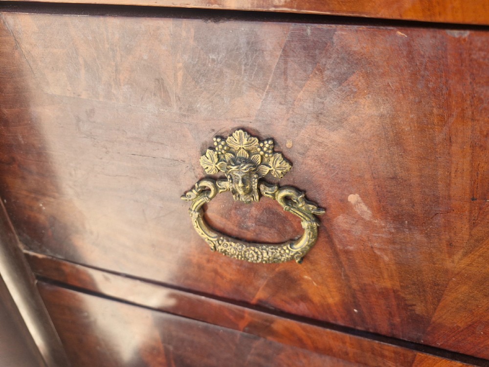 A nineteenth-century French mahogany chest of drawers featuring a dark grey marble top, four drawers with brass drop handles, and flanking side columns. View III