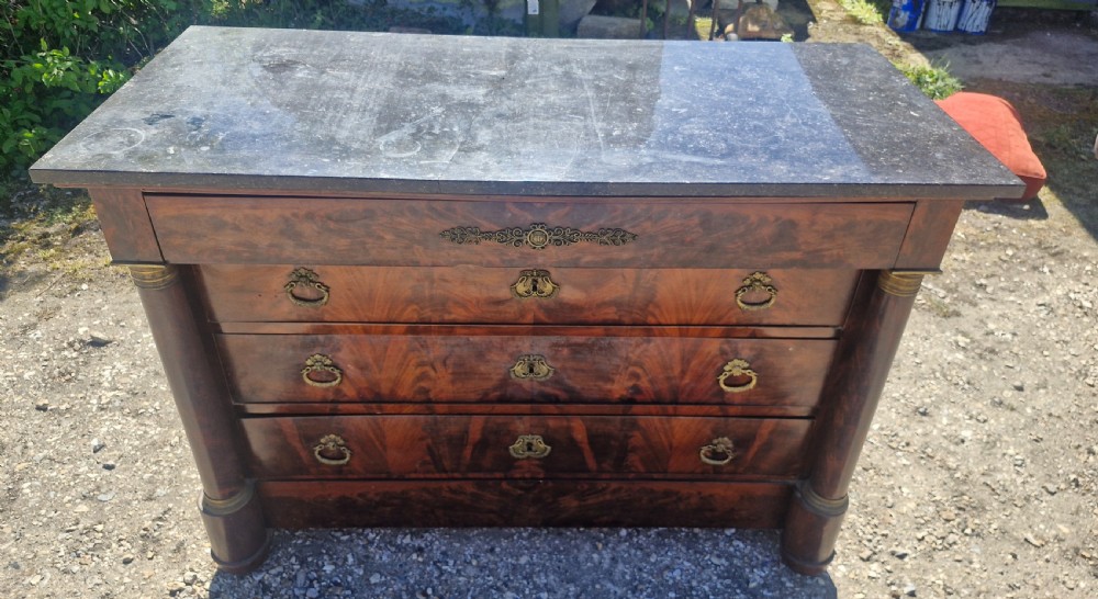 A nineteenth-century French mahogany chest of drawers featuring a dark grey marble top, four drawers with brass drop handles, and flanking side columns. View XI