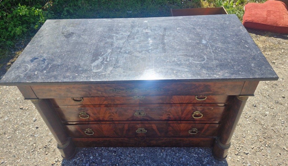 A nineteenth-century French mahogany chest of drawers featuring a dark grey marble top, four drawers with brass drop handles, and flanking side columns. View XIII