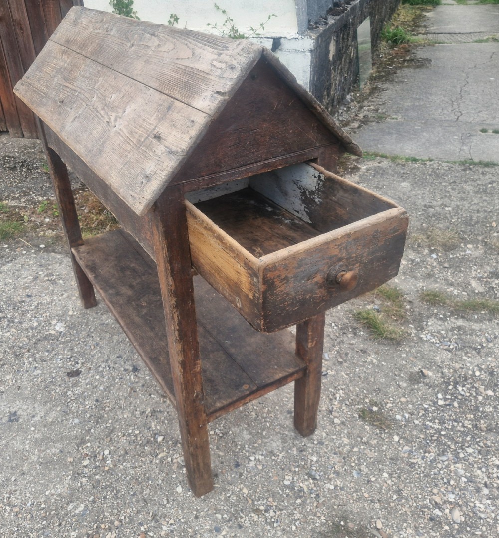 A freestanding Victorian weathered pine saddle rack featuring a pitched A-frame top, a single side drawer with a turned wooden knob, and a lower open shelf. View IV