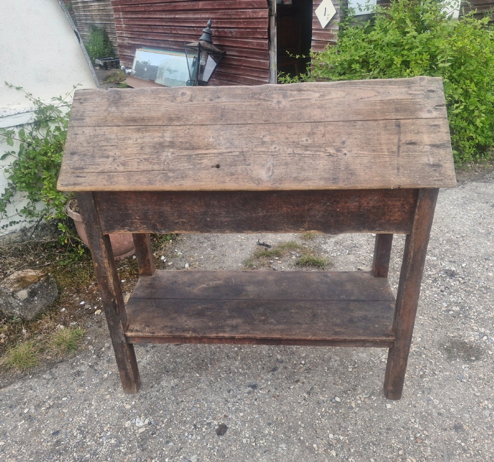 A freestanding Victorian weathered pine saddle rack featuring a pitched A-frame top, a single side drawer with a turned wooden knob, and a lower open shelf. View V