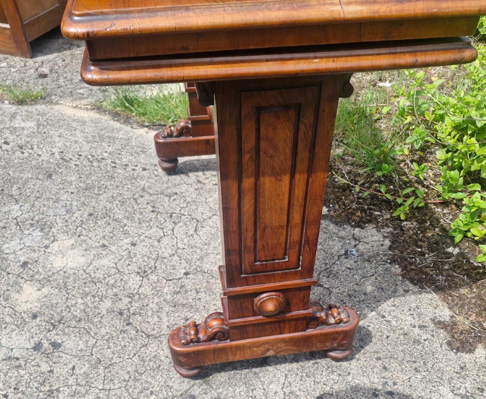 A three-tiered Victorian walnut adjustable buffet with carved lower supports resting outdoors on paved ground. View IV