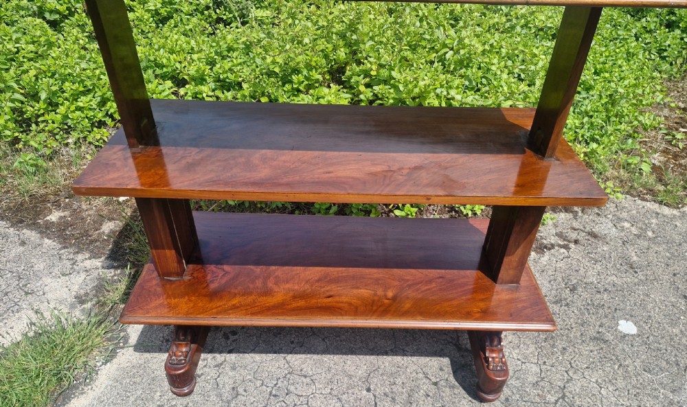 A three-tiered Victorian walnut adjustable buffet with carved lower supports resting outdoors on paved ground. View VIII