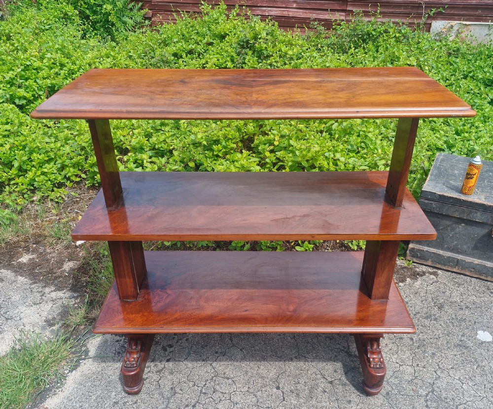 A three-tiered Victorian walnut adjustable buffet with carved lower supports resting outdoors on paved ground. View IX