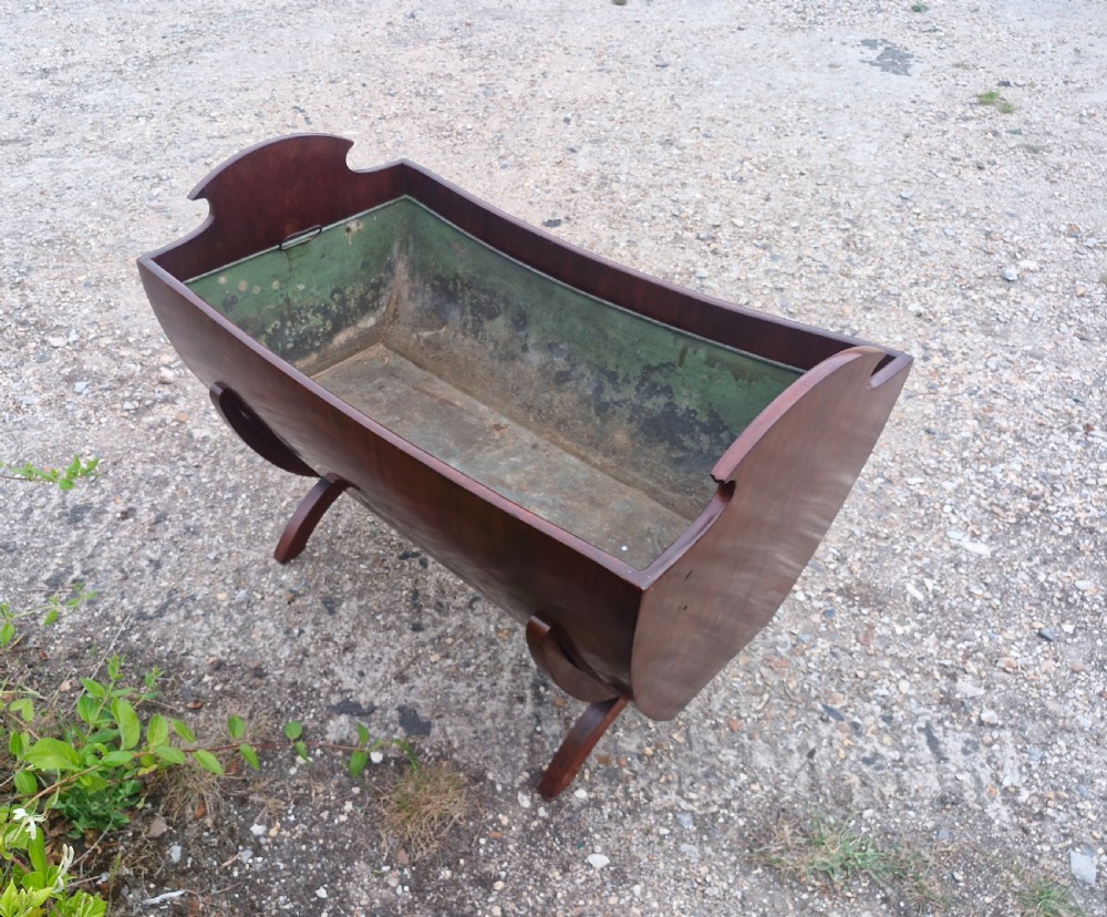 A 19th-century mahogany trough-shaped wine cooler or log bin with a removable green metal liner on splayed legs. View VII