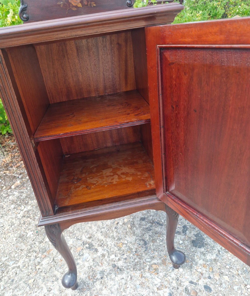 A late Victorian dark mahogany bedside cabinet featuring floral marquetry inlay on the door and gallery splashback. View IV