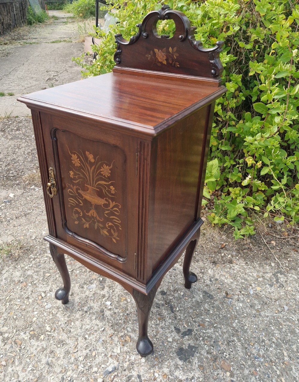 A late Victorian dark mahogany bedside cabinet featuring floral marquetry inlay on the door and gallery splashback. View V
