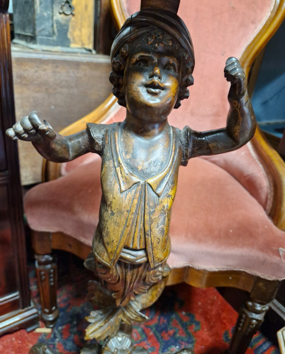A late 19th-century carved dark walnut gueridon stand featuring a scalloped top supported by a carved figurative stem on a tripod base. View V