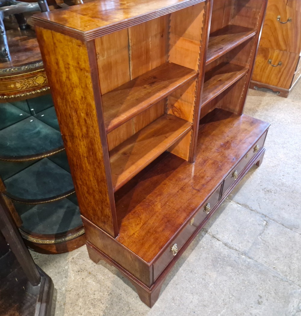 A Regency mahogany dwarf bookcase featuring open adjustable shelves above two lower drawers with brass ring handles. View III