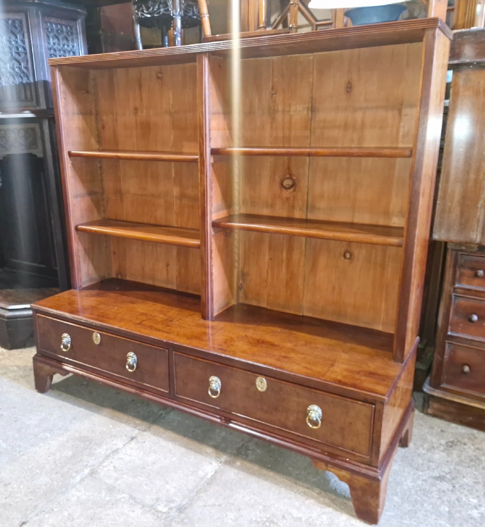A Regency mahogany dwarf bookcase featuring open adjustable shelves above two lower drawers with brass ring handles. View IV