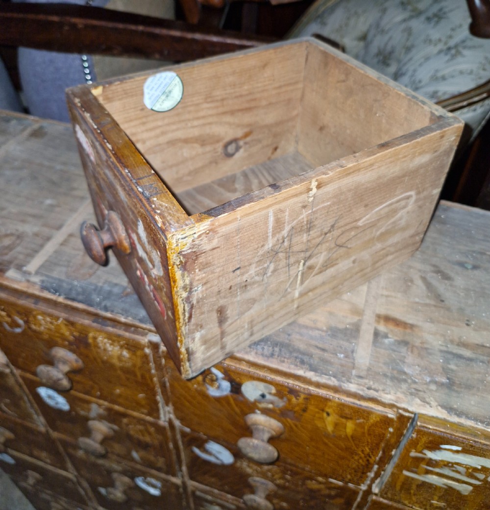 A late Victorian wooden bank of drawers featuring thirty individual drawers arranged in a five by six grid with turned wooden knob handles. View II