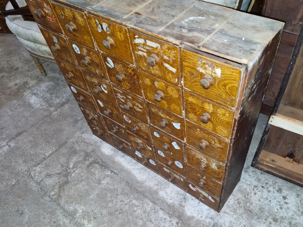A late Victorian wooden bank of drawers featuring thirty individual drawers arranged in a five by six grid with turned wooden knob handles. View III