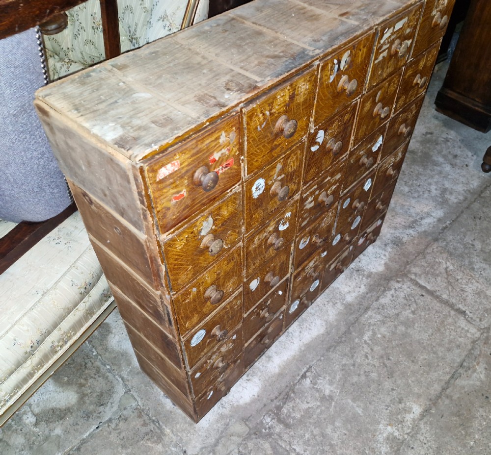 A late Victorian wooden bank of drawers featuring thirty individual drawers arranged in a five by six grid with turned wooden knob handles. View V