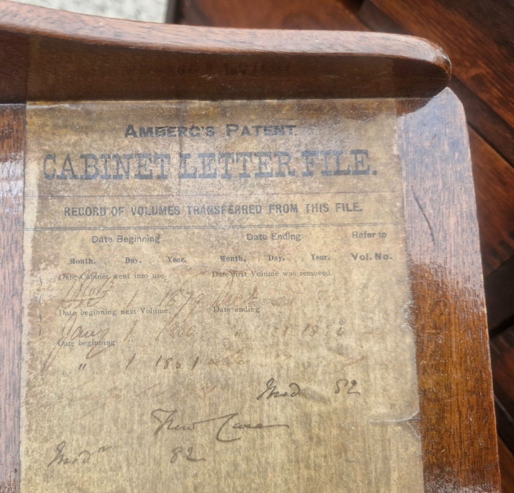 A 19th-century Victorian wooden tabletop Amberg filing cabinet with indexed drawers and an upper spring-loaded letter binder. View IV