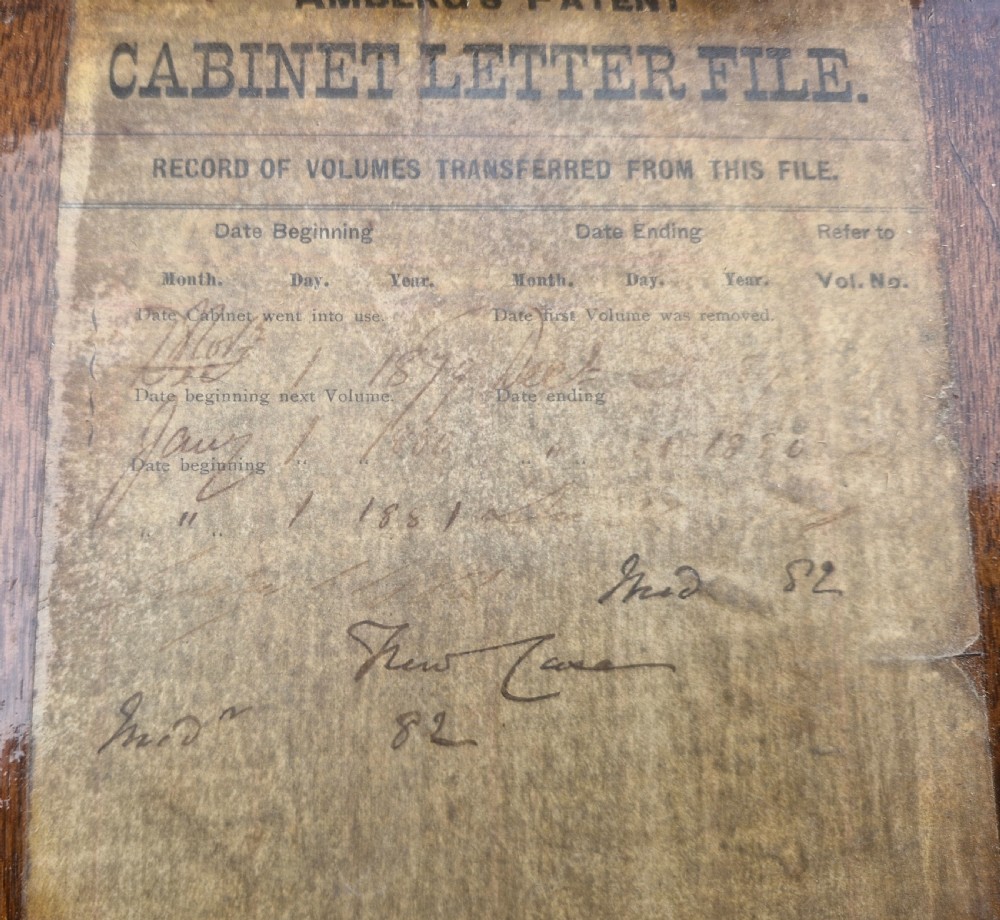 A 19th-century Victorian wooden tabletop Amberg filing cabinet with indexed drawers and an upper spring-loaded letter binder. View VI