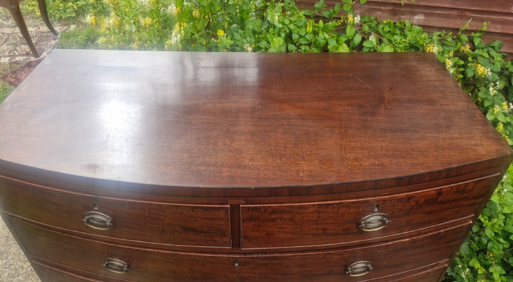 A Regency mahogany bow front chest of drawers featuring two short over three long graduated drawers with brass handles and splayed bracket feet. View III
