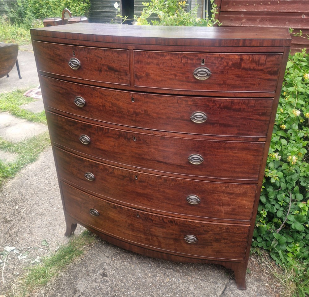 A Regency mahogany bow front chest of drawers featuring two short over three long graduated drawers with brass handles and splayed bracket feet. View VI