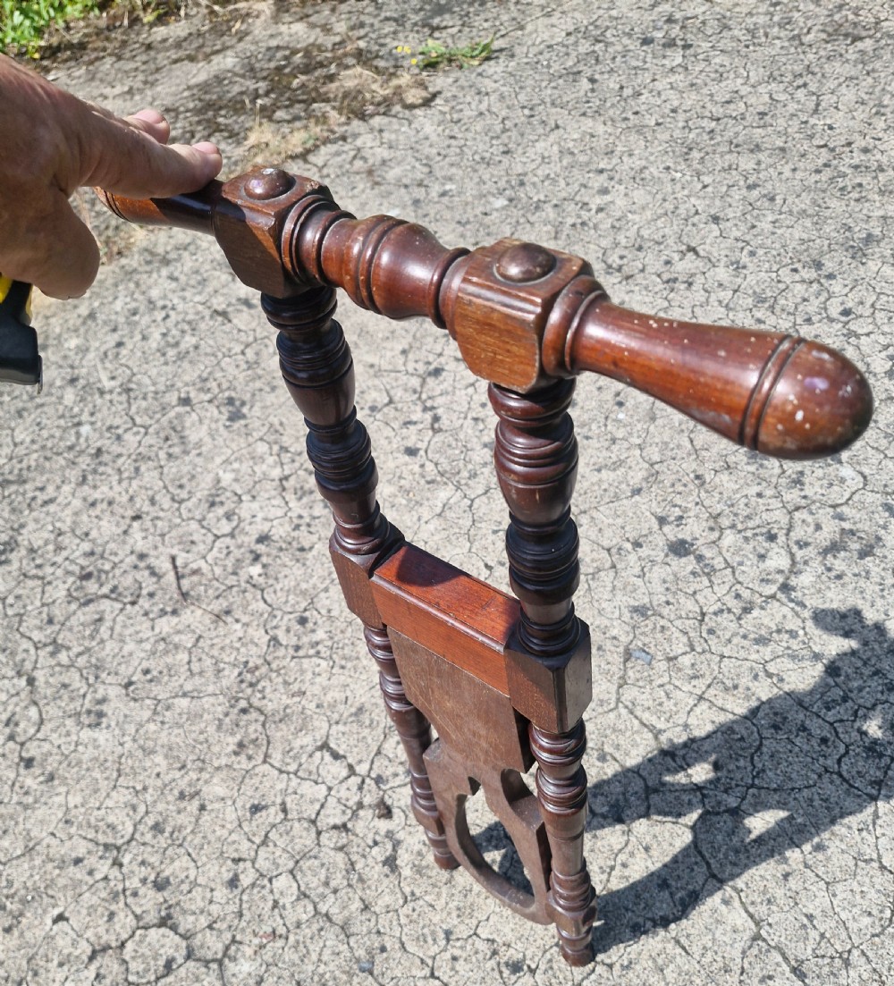 A late Victorian turned dark wood freestanding boot jack with twin upright handles and a horseshoe-shaped base for boot removal. View III