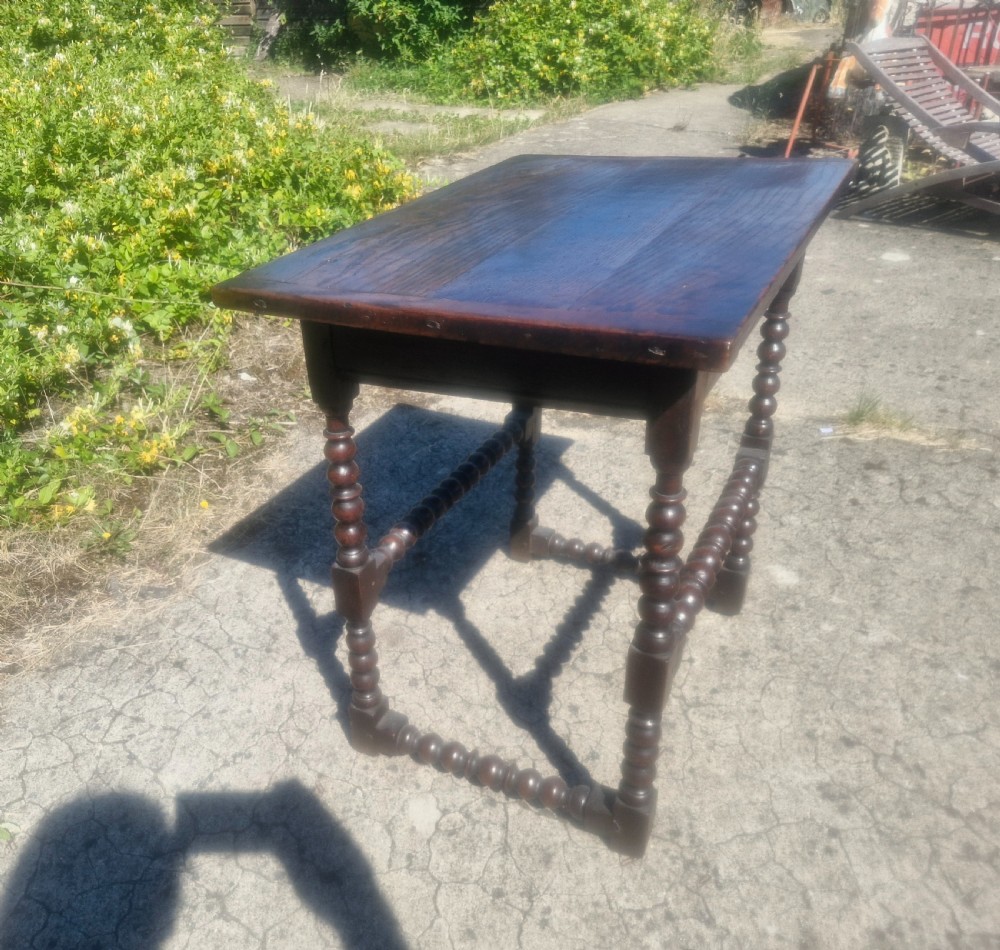A mid-18th century dark oak side table featuring bobbin-turned legs and perimeter stretchers. View II