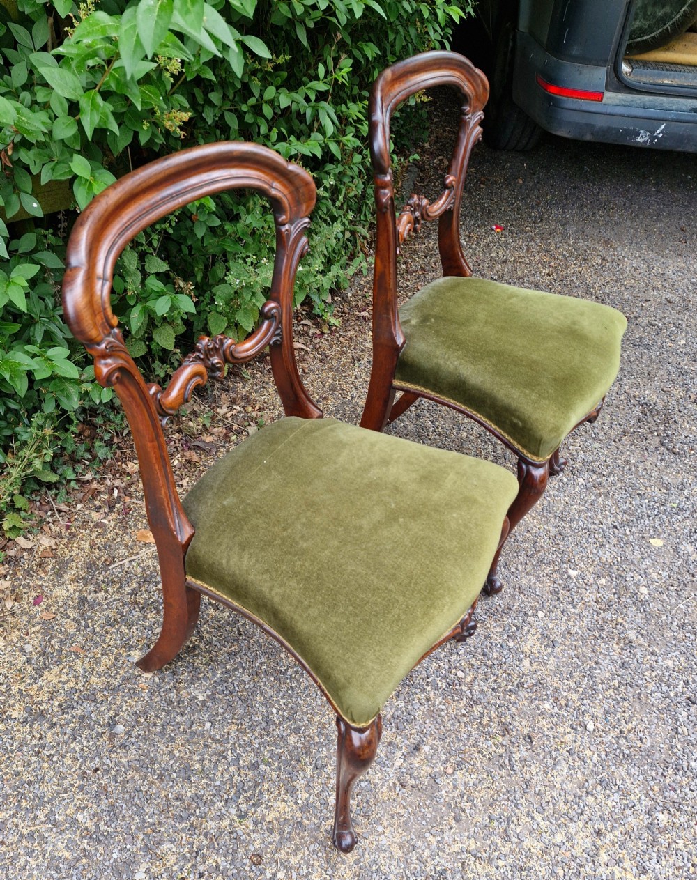 A pair of early Victorian rosewood balloon back side chairs featuring carved foliate splats, cabriole front legs, and green velvet upholstered seats. View III