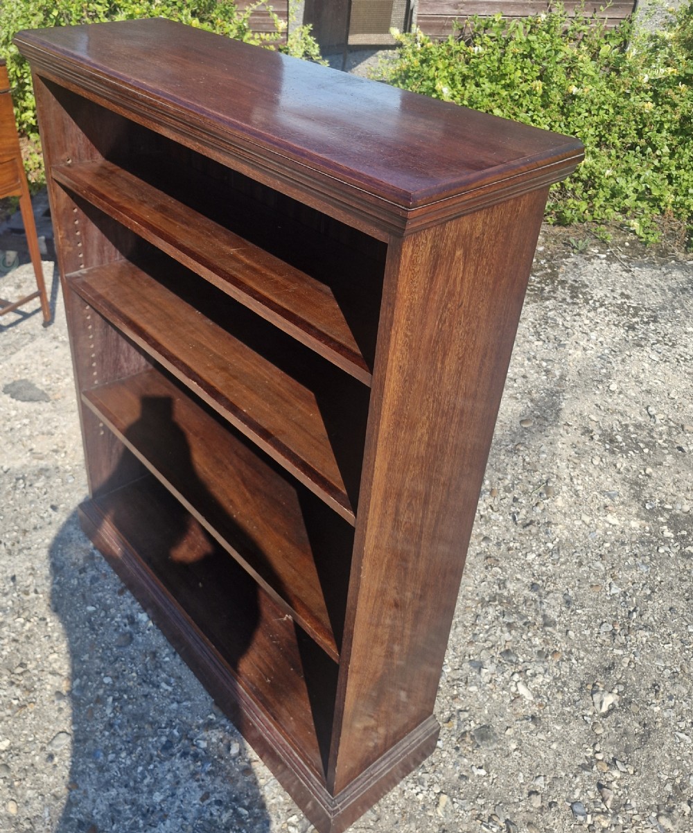 A low dark mahogany open front bookcase featuring four shelves, a moulded top, and a solid plinth base. View III