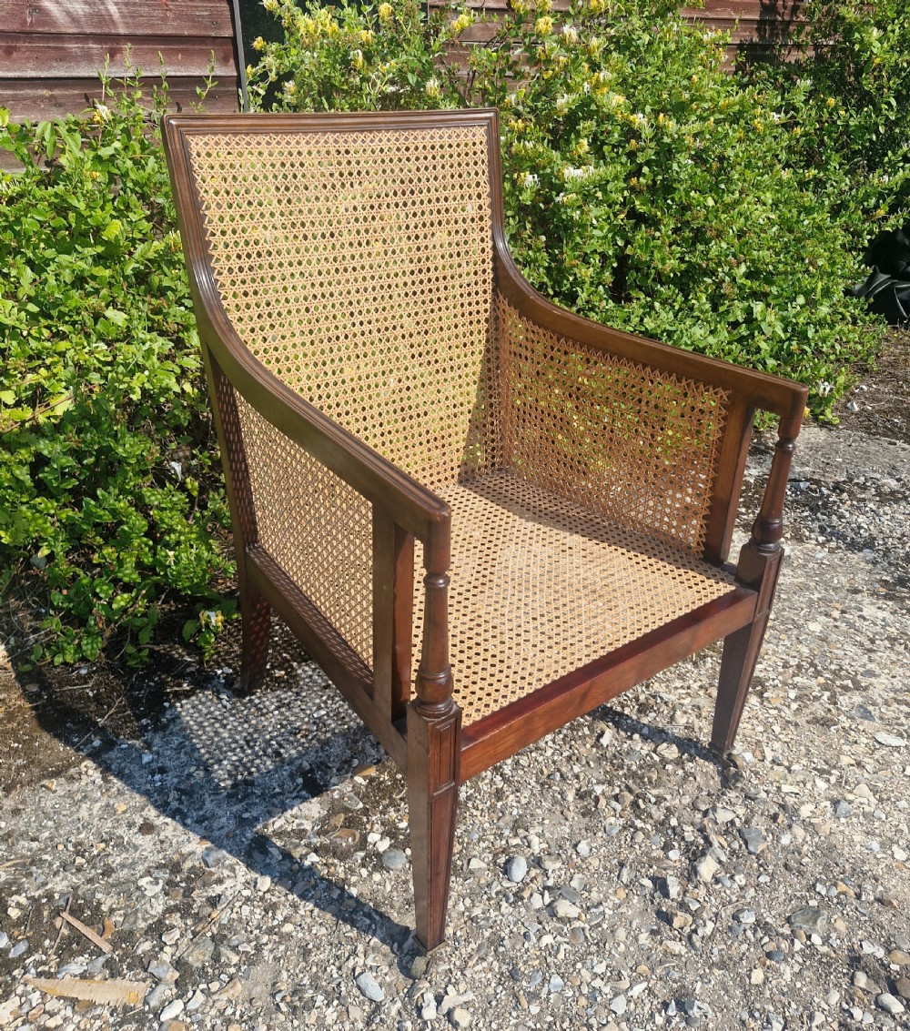Mahogany bergere caned armchair with original cushions.  View II