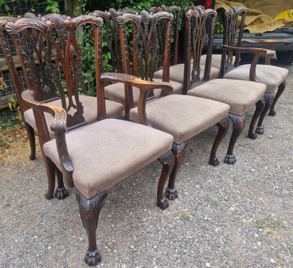 A set of eight dark mahogany Chippendale style dining chairs featuring carved splat backs, cabriole legs with ball and claw feet, and neutral patterned fabric seats. View V
