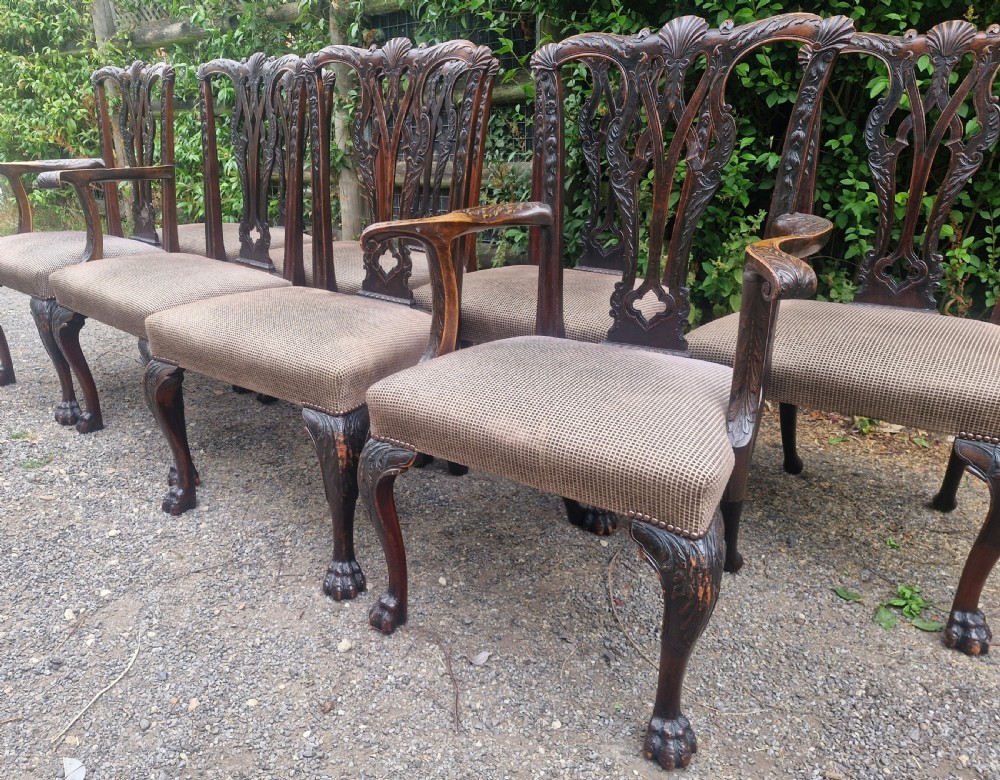 A set of eight dark mahogany Chippendale style dining chairs featuring carved splat backs, cabriole legs with ball and claw feet, and neutral patterned fabric seats. View IX