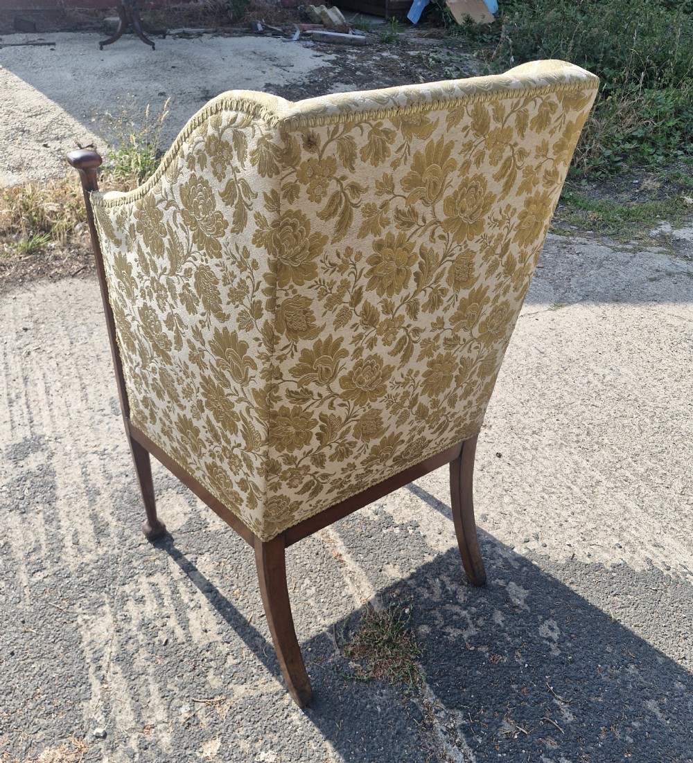 An Art Nouveau mahogany armchair featuring a high back, gold floral damask upholstery, boxwood inlay stringing, and extended vertical side supports ending in rounded finials. View III
