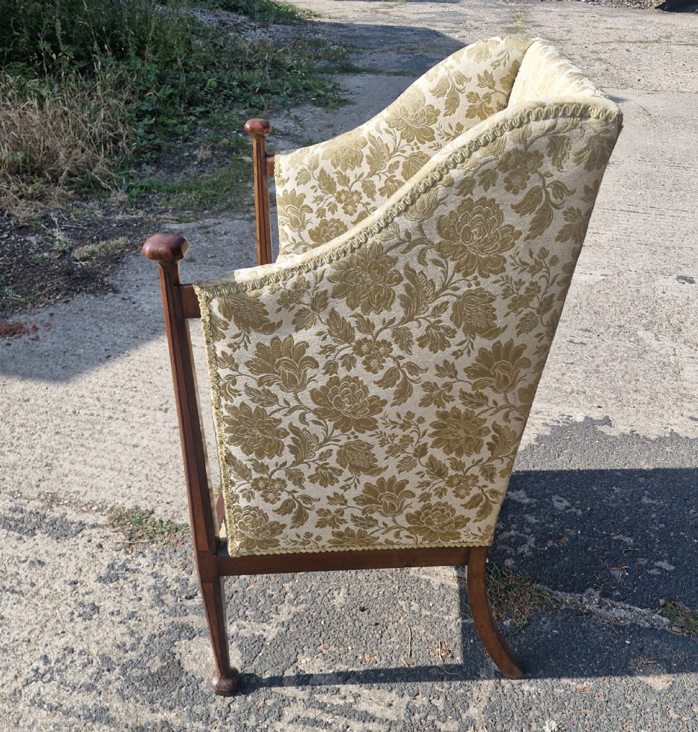 An Art Nouveau mahogany armchair featuring a high back, gold floral damask upholstery, boxwood inlay stringing, and extended vertical side supports ending in rounded finials. View V