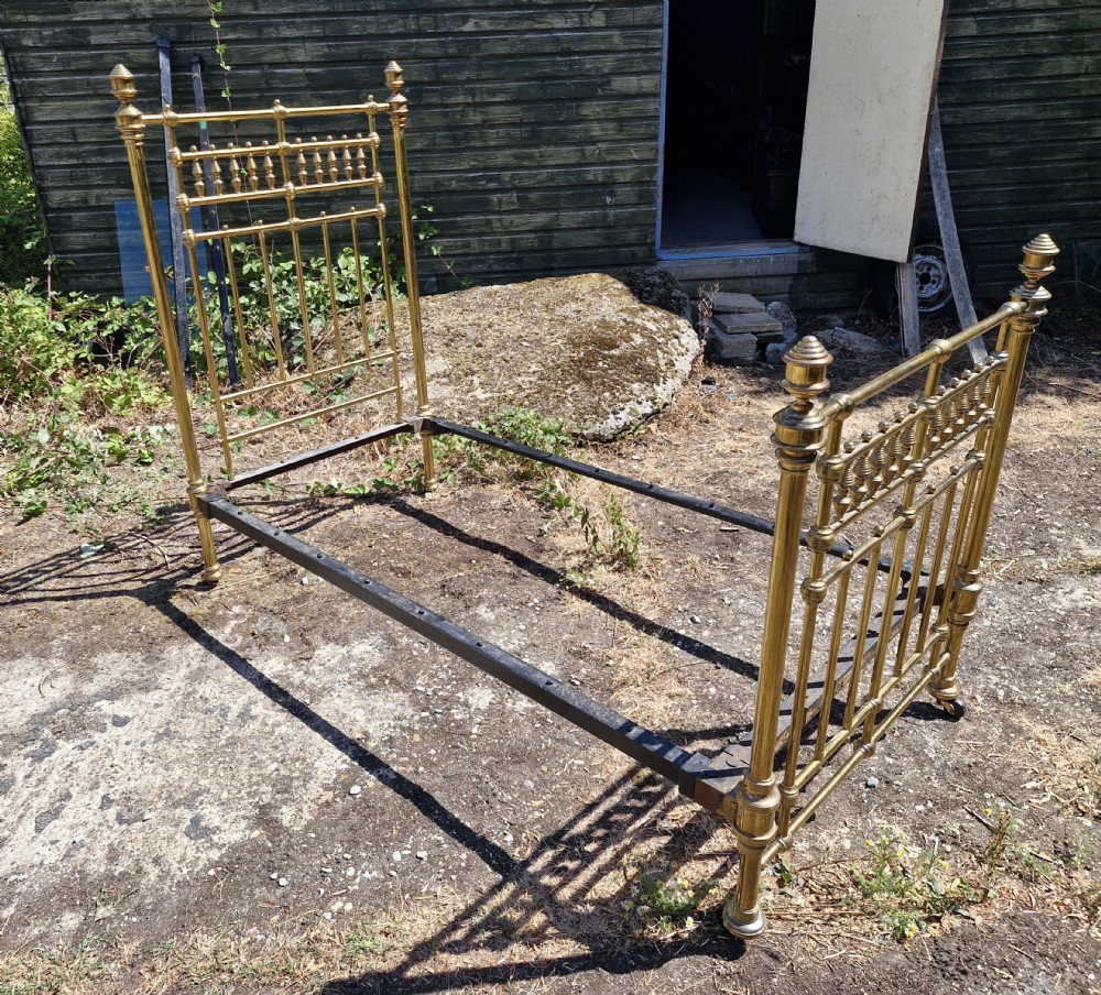Victorian brass single bedstead featuring turned finials, spindled headboard and footboard, and iron side rails. View II