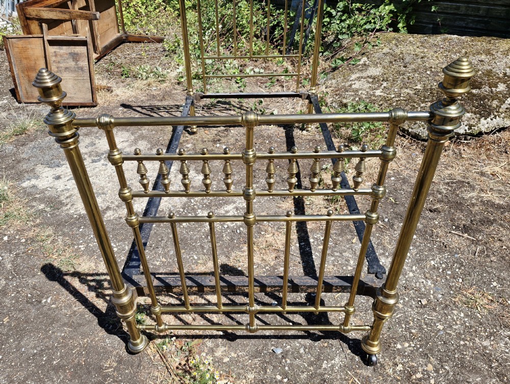 Victorian brass single bedstead featuring turned finials, spindled headboard and footboard, and iron side rails. View III