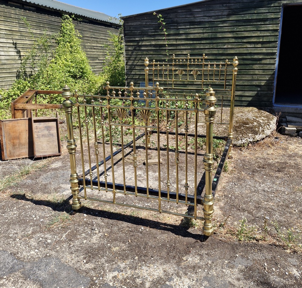 A Victorian double brass bed frame featuring turned posts, decorative finials, vertical metal spindles, and cast iron side rails. View IV