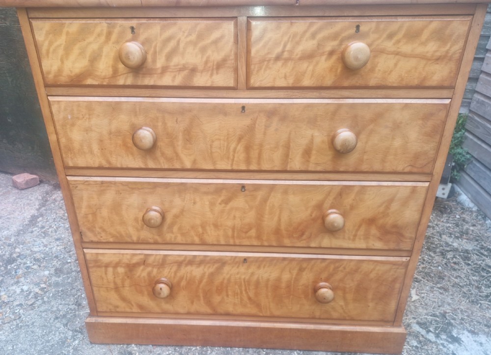 A Victorian satin birch chest of drawers featuring two short drawers over three long graduated drawers with turned wooden handles. View II