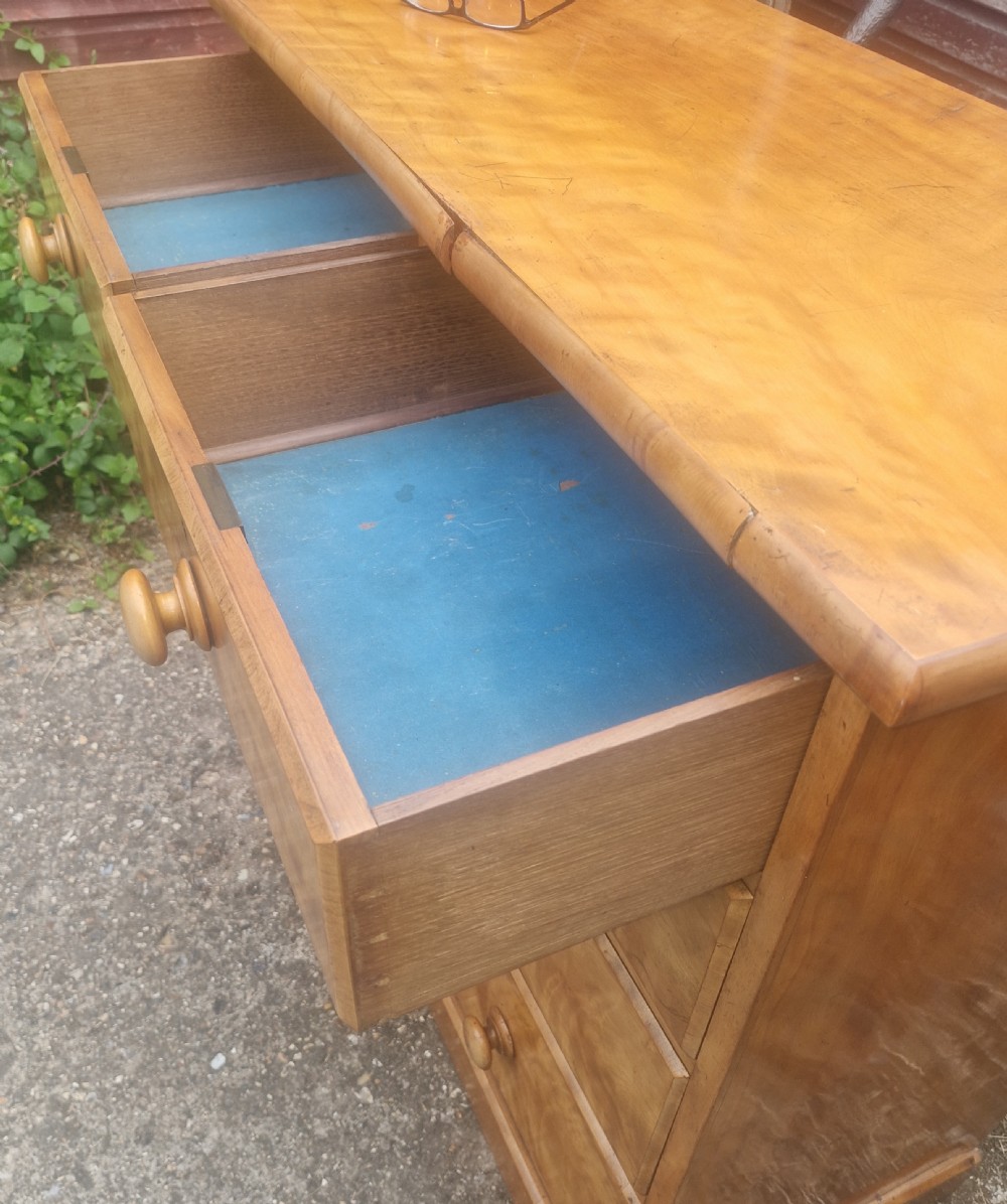 A Victorian satin birch chest of drawers featuring two short drawers over three long graduated drawers with turned wooden handles. View III