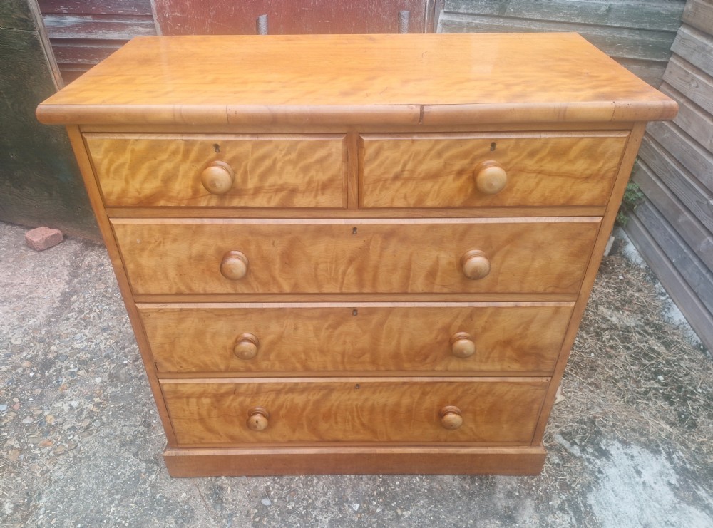 A Victorian satin birch chest of drawers featuring two short drawers over three long graduated drawers with turned wooden handles. View VII