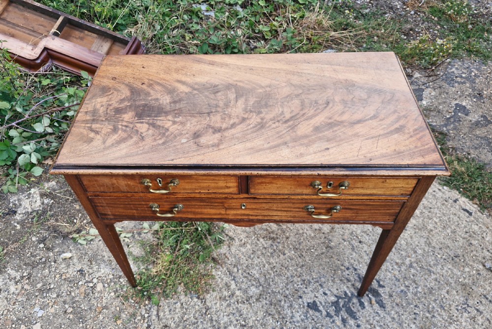 An early 19th-century mahogany side table featuring a rectangular top, three drawers with brass handles, and slender square tapered legs. View IV