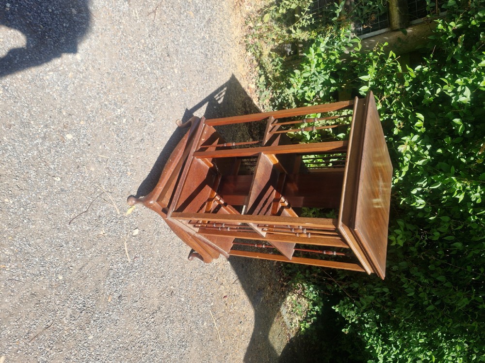 An Edwardian mahogany revolving bookcase featuring open square shelving with vertical turned spindles and a moulded top. View III