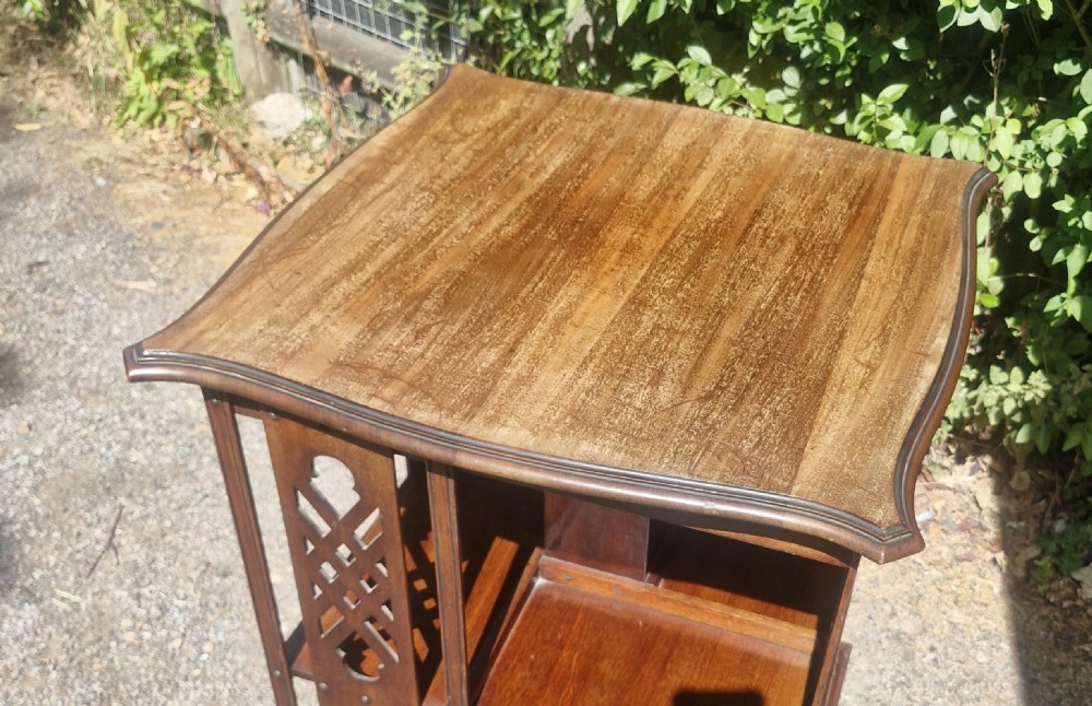 An Edwardian mahogany revolving bookcase featuring a square moulded top surface and pierced fretwork side panels. View III