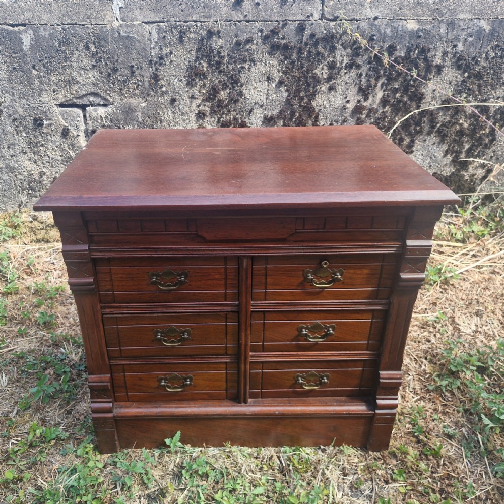 A warm brown mahogany desktop bank of six drawers featuring carved pilasters, grooved drawer fronts, and brass drop handles. View II