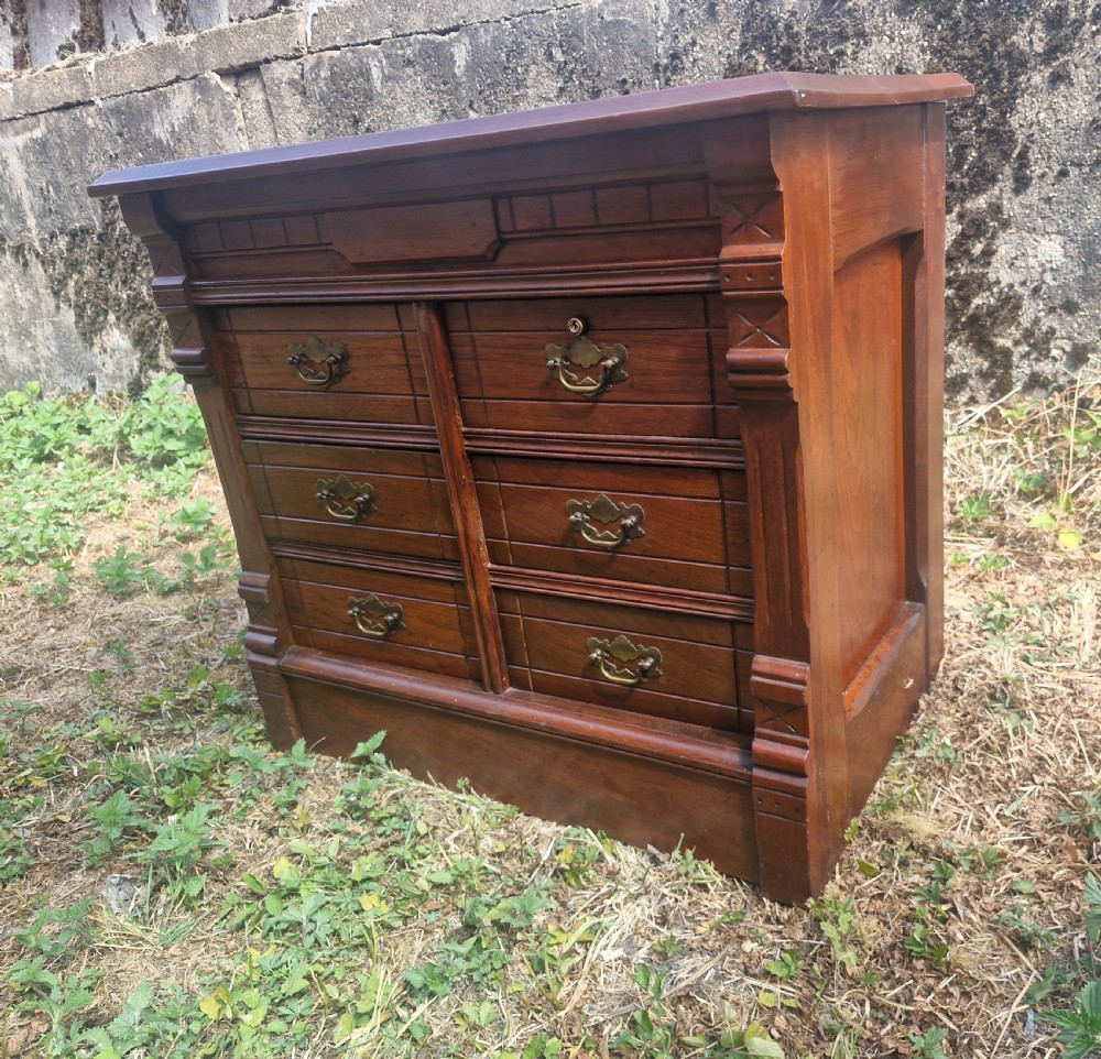 A warm brown mahogany desktop bank of six drawers featuring carved pilasters, grooved drawer fronts, and brass drop handles. View III
