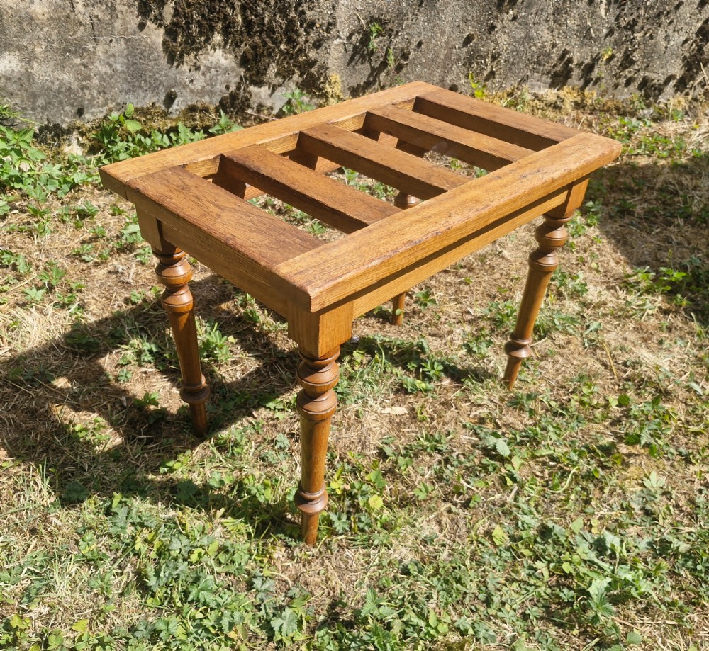 An Edwardian ash luggage stand with a rectangular slatted timber top and four turned wooden legs. View V