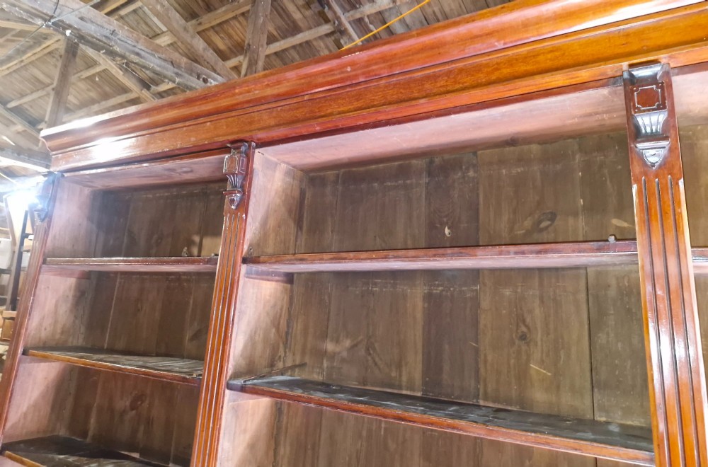 A large, three-section antique mahogany open-front bookcase with adjustable shelves and fluted pilasters. View V
