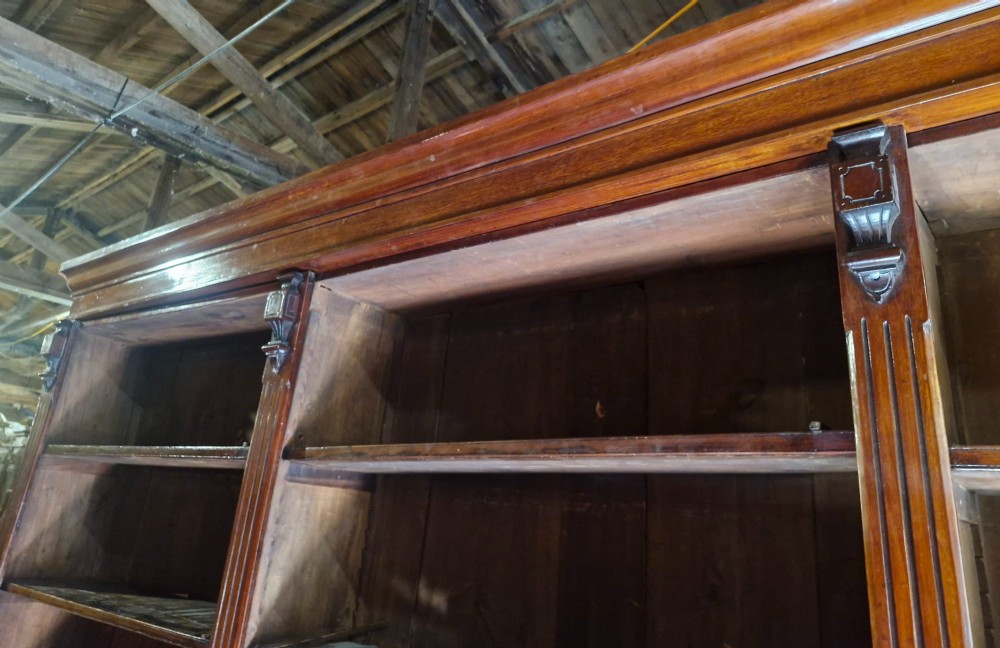 A large, three-section antique mahogany open-front bookcase with adjustable shelves and fluted pilasters. View VIII